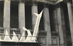 Large inflatable sculpture in front of civic building and a crowd of people